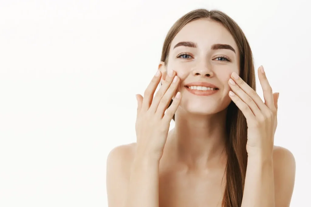 Mulher tocando seu rosto feliz com os resultados da toxina botulínica