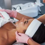 Mulher deitada em clínica de estética recebendo limpeza de pele com alta frequência