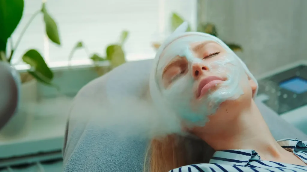 Mulher aplicando vapor de ozônio no rosto durante tratamento estético, ilustrando para que serve o vapor de ozônio.