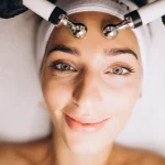 Mulher sorrindo enquanto faz tratamento de microcorrentes em uma clínica de estética