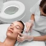 Profissional de estética aplicando preenchimento facial no rosto de sua cliente durante procedimento estético.